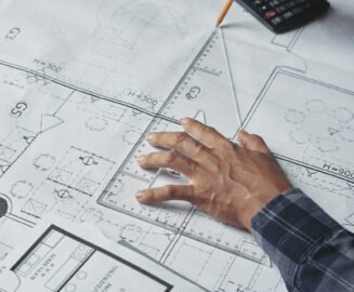 Hands of architect drawing blueprint of the house