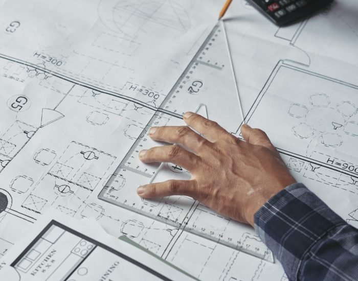 Hands of architect drawing blueprint of the house
